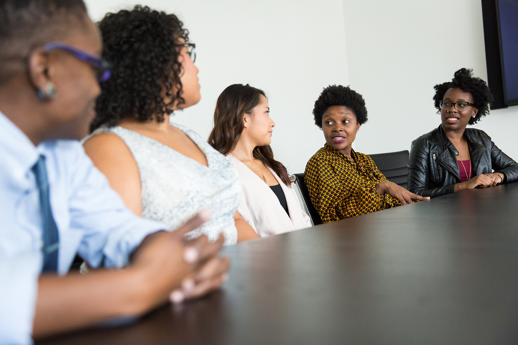 a diverse group of people at a conference room table